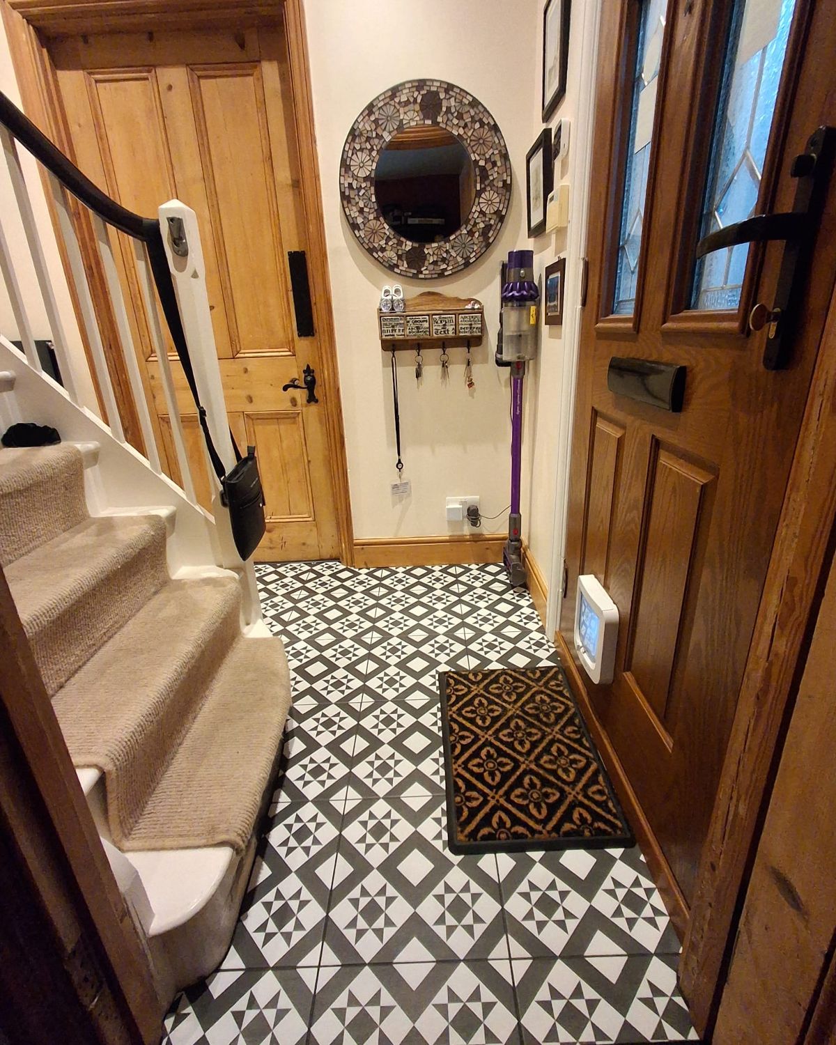 After: the same front-door end repainted, tiled, with mirror and hooks up