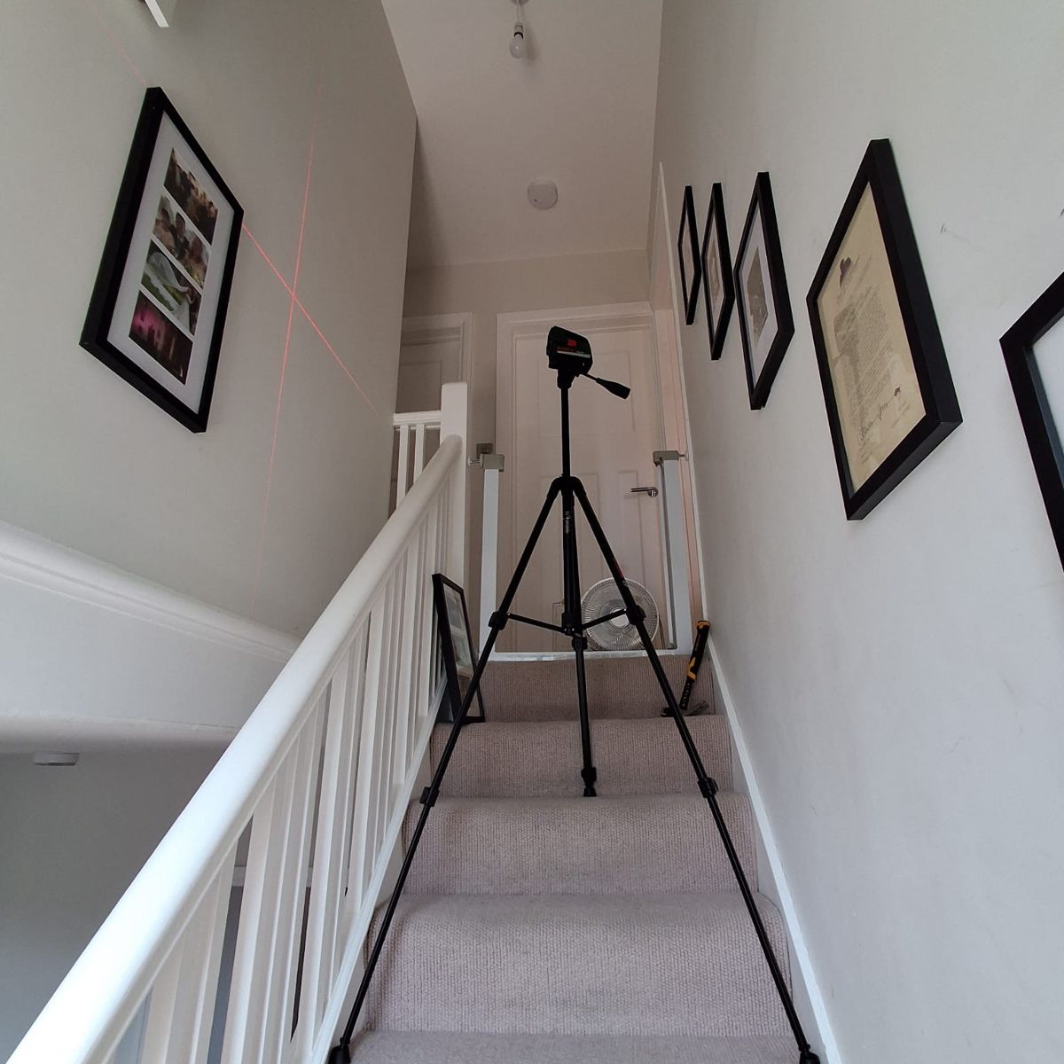 After: a row of framed pictures hung level along both stairwell walls
