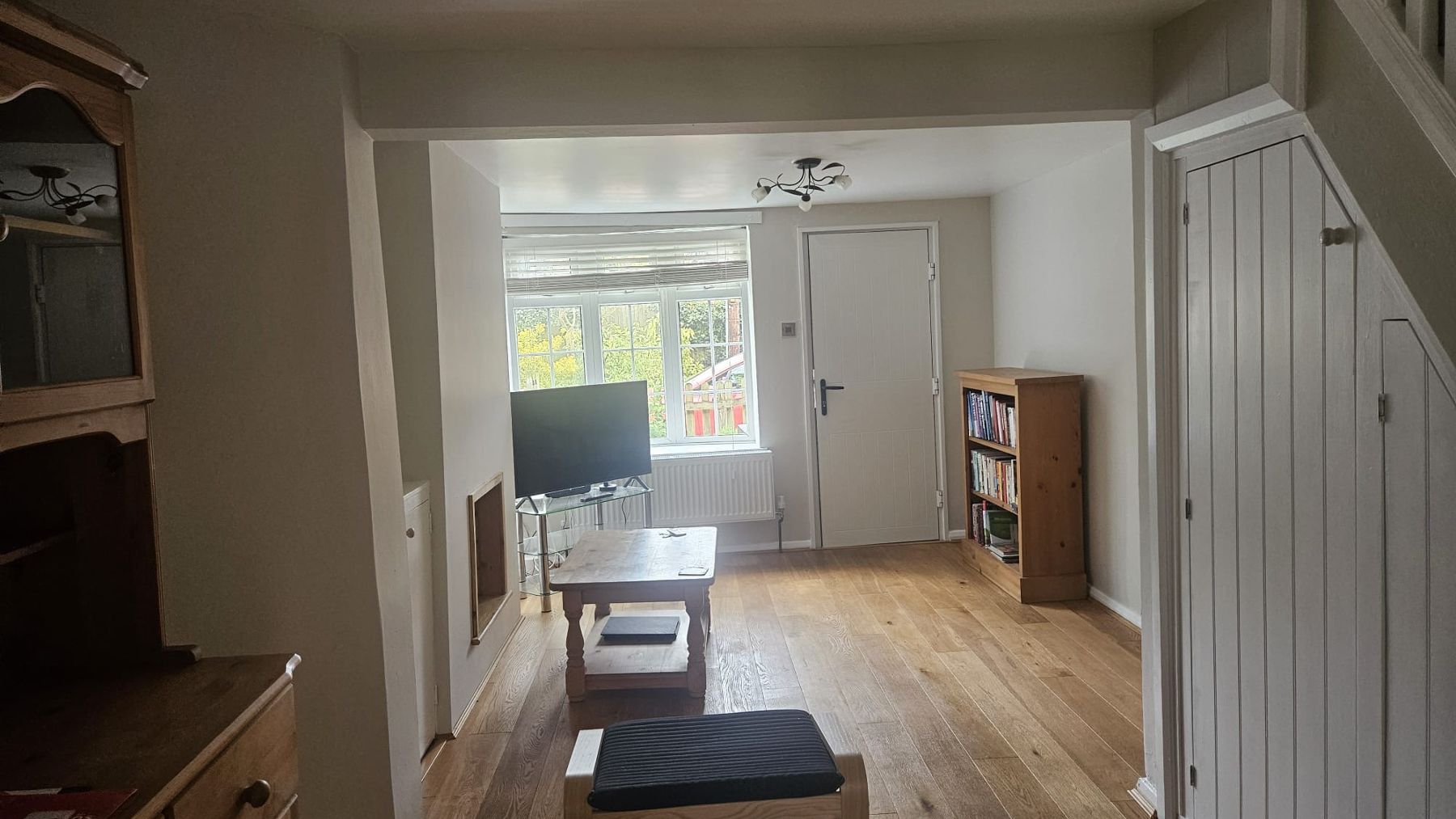 After: the living room painted through, walls and ceiling fresh, furniture back in place