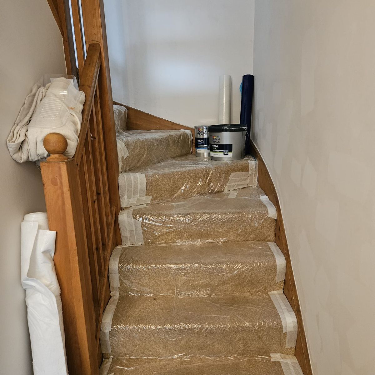 After: a stairwell with freshly painted walls, floors still protected