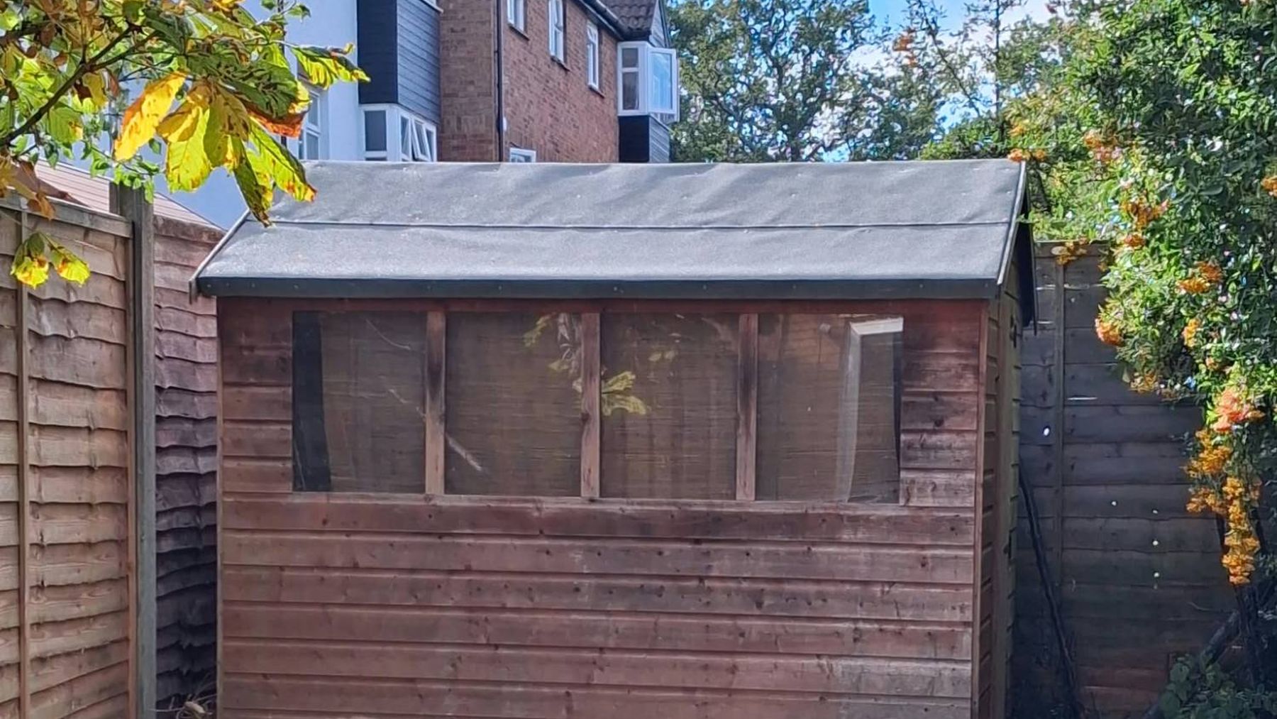 After: the shed roof finished in new grey felt, edges trimmed neatly