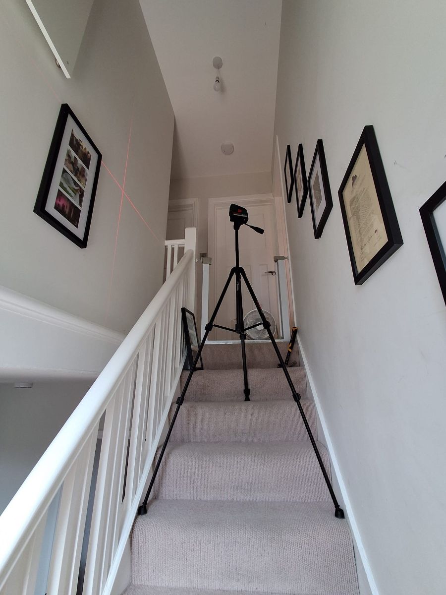 A row of framed pictures hung level along a freshly painted stairwell